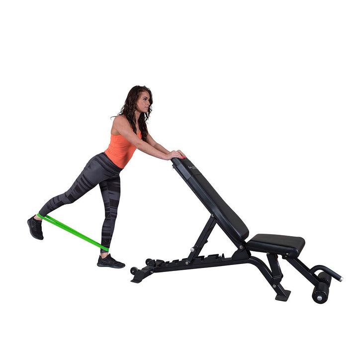 User performing a bench-supported leg exercise using a Body-Solid Tools mini resistance band.