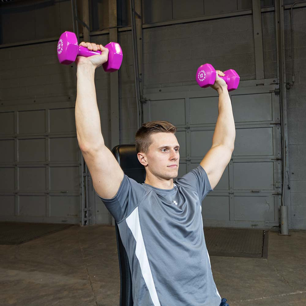 Person performing a shoulder press with pink Body-Solid vinyl dumbbells