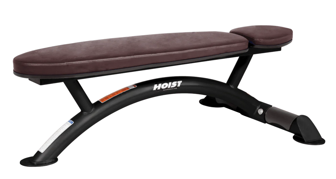 Hoist commercial flat bench with burgundy padding and curved steel frame for weightlifting and strength training