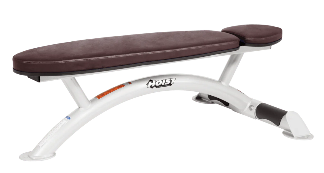 Hoist commercial flat bench with white burgundy padding and curved steel frame for weightlifting and strength training