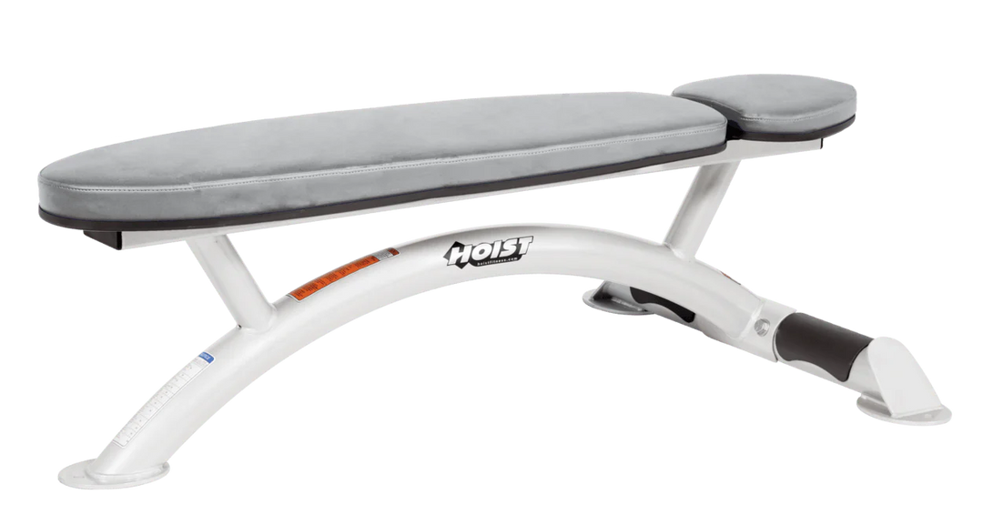 Hoist commercial flat bench with white padding and curved steel frame for weightlifting and strength training