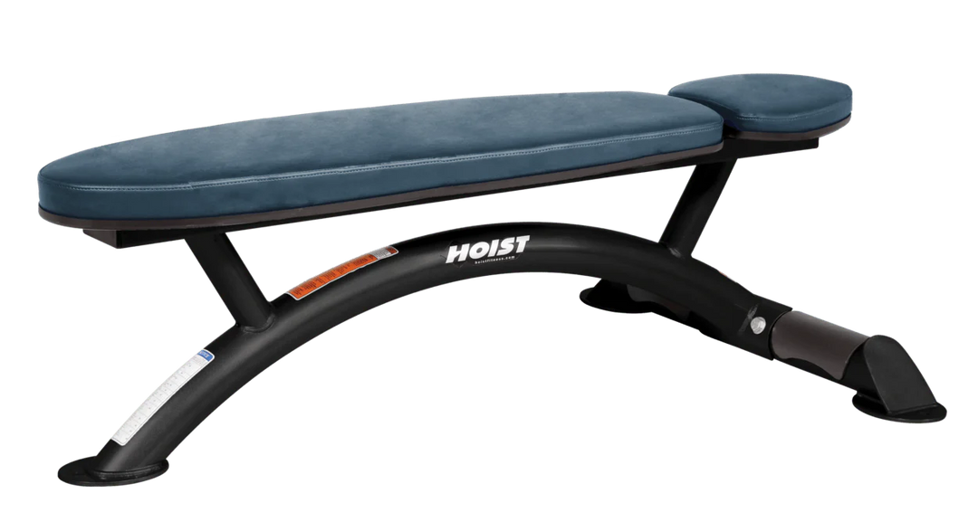 Hoist commercial flat bench with navy blue padding and curved steel frame for weightlifting and strength training