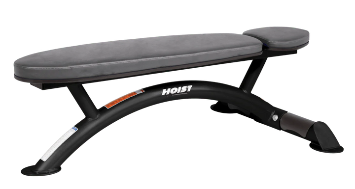 Hoist commercial flat bench with slate grey padding and curved steel frame for weightlifting and strength training