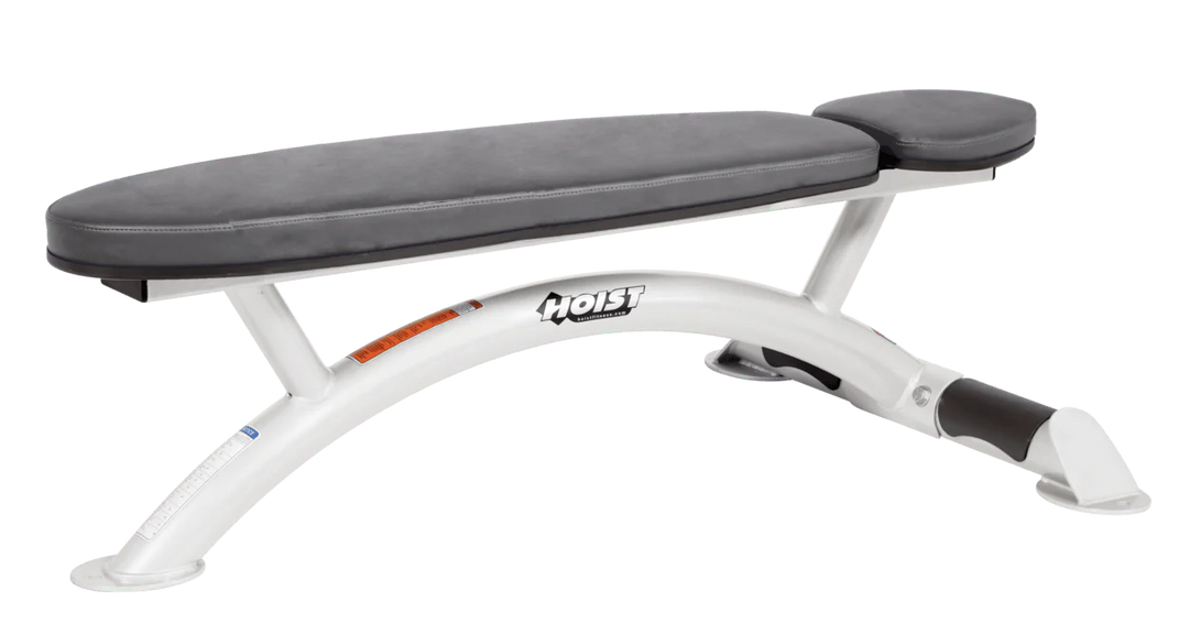 Hoist commercial flat bench with white slate grey padding and curved steel frame for weightlifting and strength training