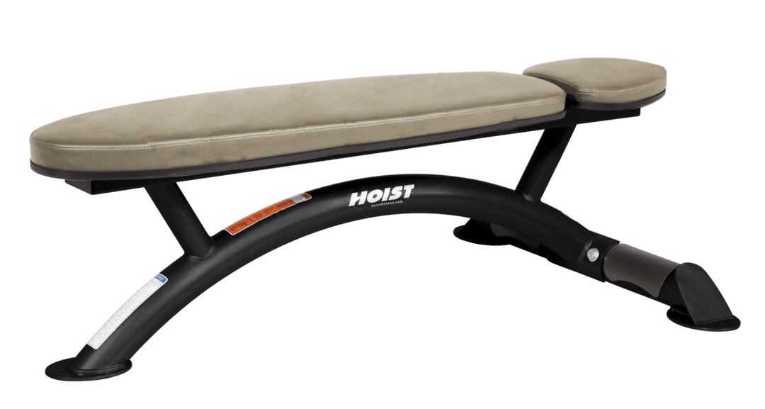 Hoist commercial flat bench with suede padding and curved steel frame for weightlifting and strength training