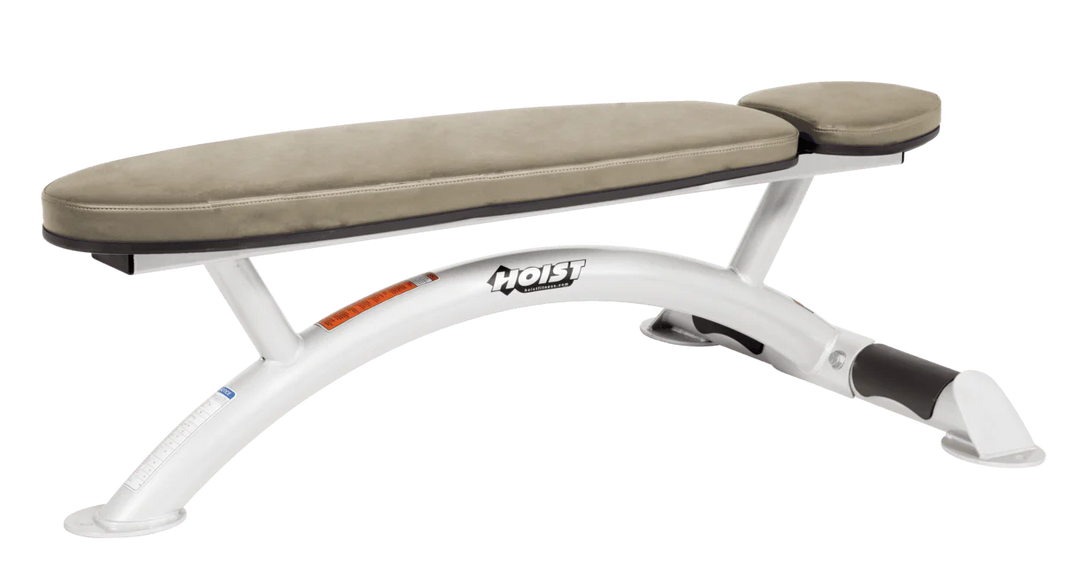 Hoist commercial flat bench with white suede padding and curved steel frame for weightlifting and strength training