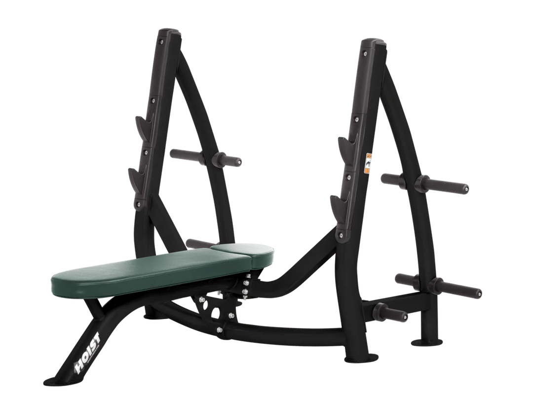 Hoist hunter green commercial Olympic flat bench with built-in weight plate storage and barbell rack for strength training