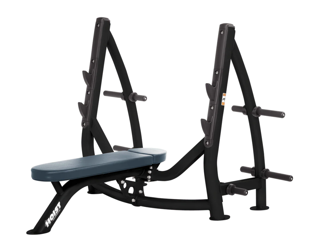 Hoist navy blue commercial Olympic flat bench with built-in weight plate storage and barbell rack for strength training