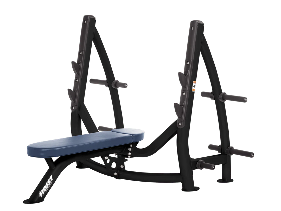 Hoist royal blue commercial Olympic flat bench with built-in weight plate storage and barbell rack for strength training