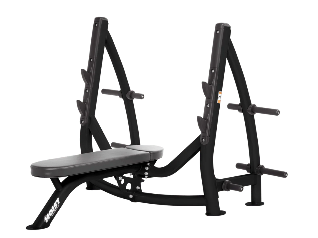 Hoist slate grey commercial Olympic flat bench with built-in weight plate storage and barbell rack for strength training