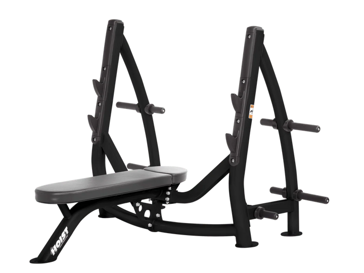 Hoist slate grey commercial Olympic flat bench with built-in weight plate storage and barbell rack for strength training