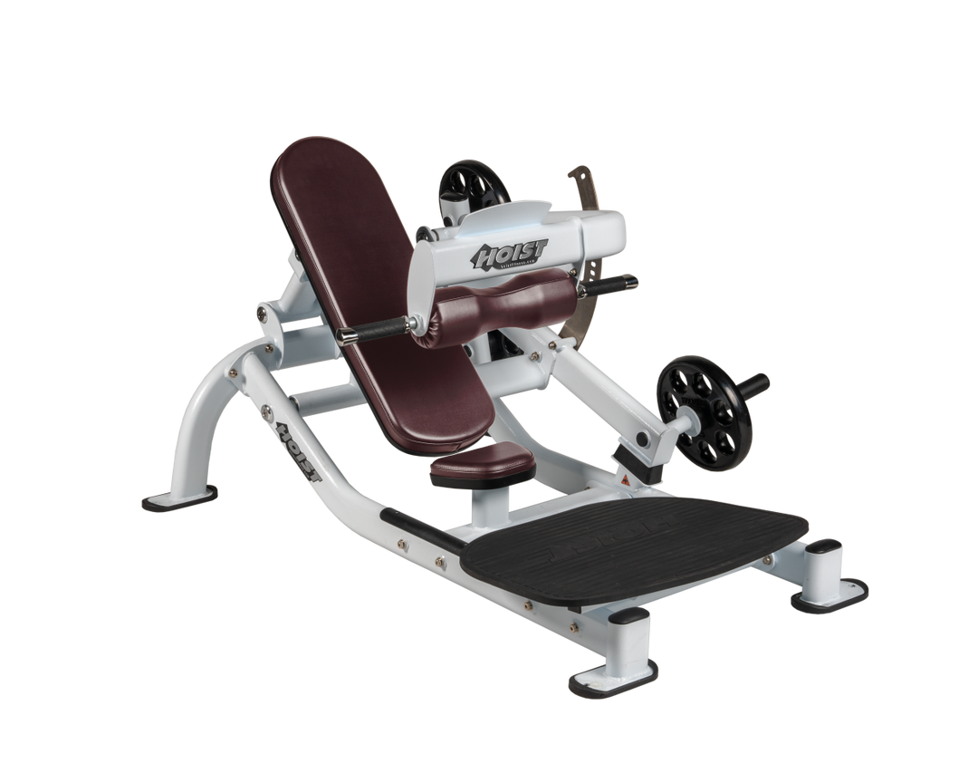 Angled view of BRG white glute thrust machine showing foot platform, seat, and weight plate loading positions