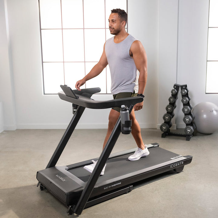 Centr Runr folding treadmill in use for a walking workout in a home fitness space