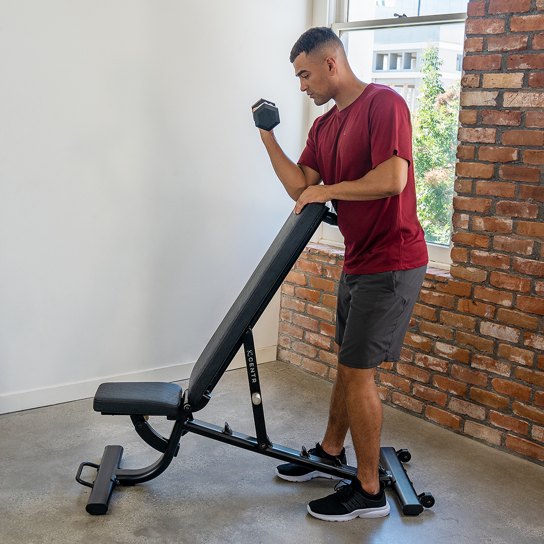 Centr adjustable workout bench being set to an incline back-pad position for strength training