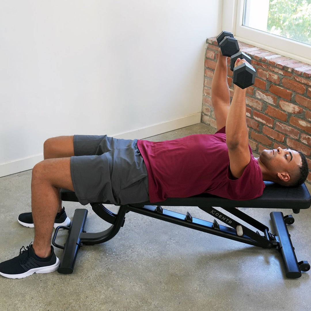 Centr adjustable workout bench used in the flat position for a dumbbell press exercise