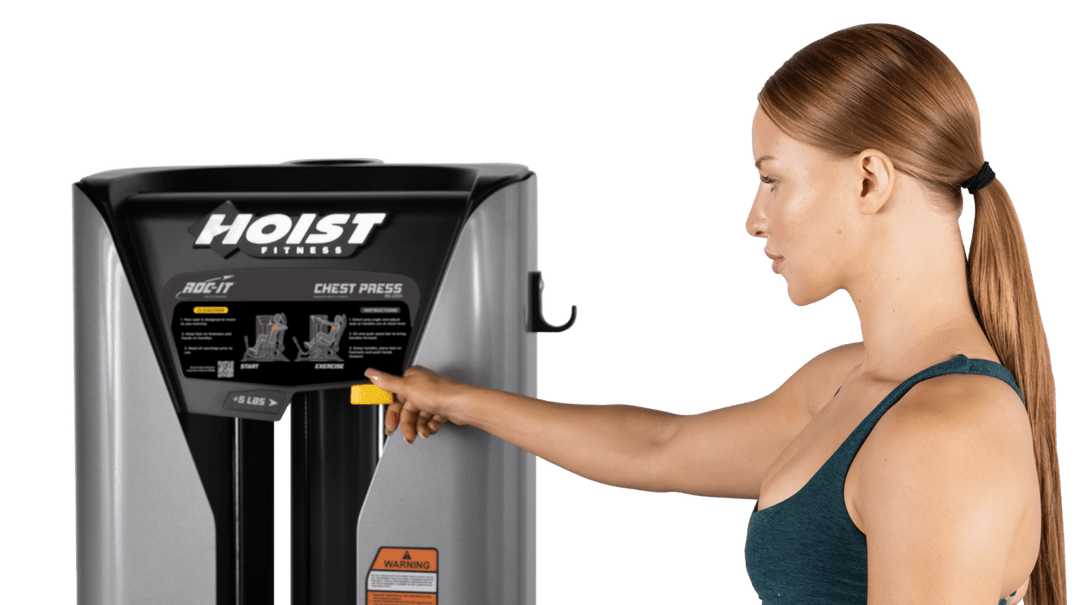 user adjusting selectorized weight stack on chest press machine for customized resistance