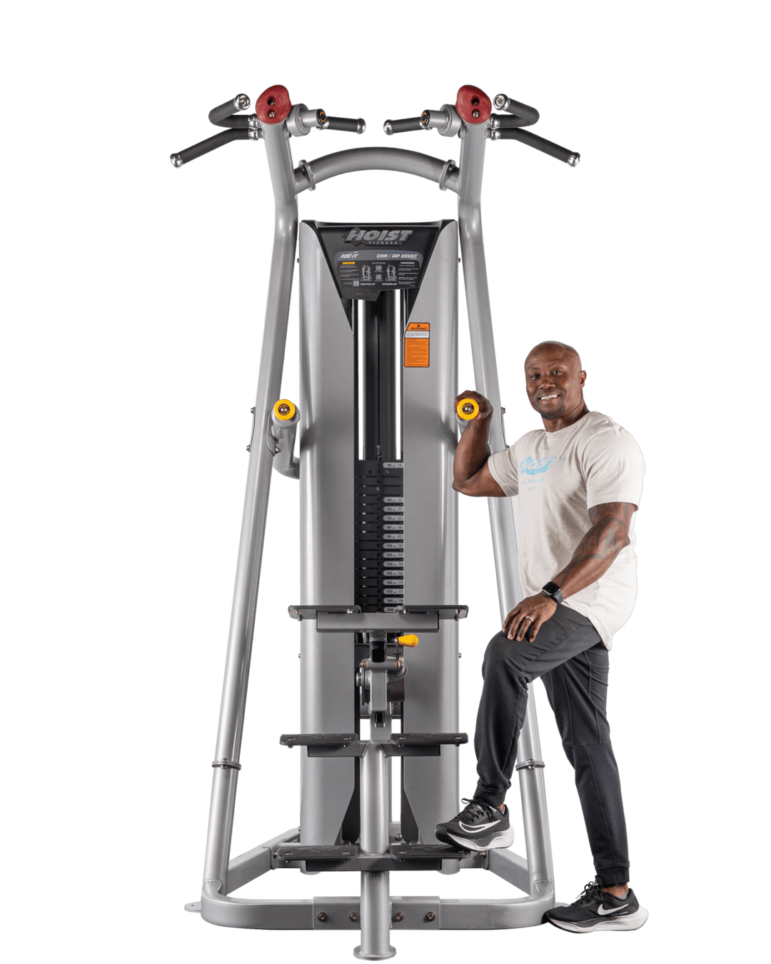 man standing on assist platform holding handles preparing for chin-up or dip exercise