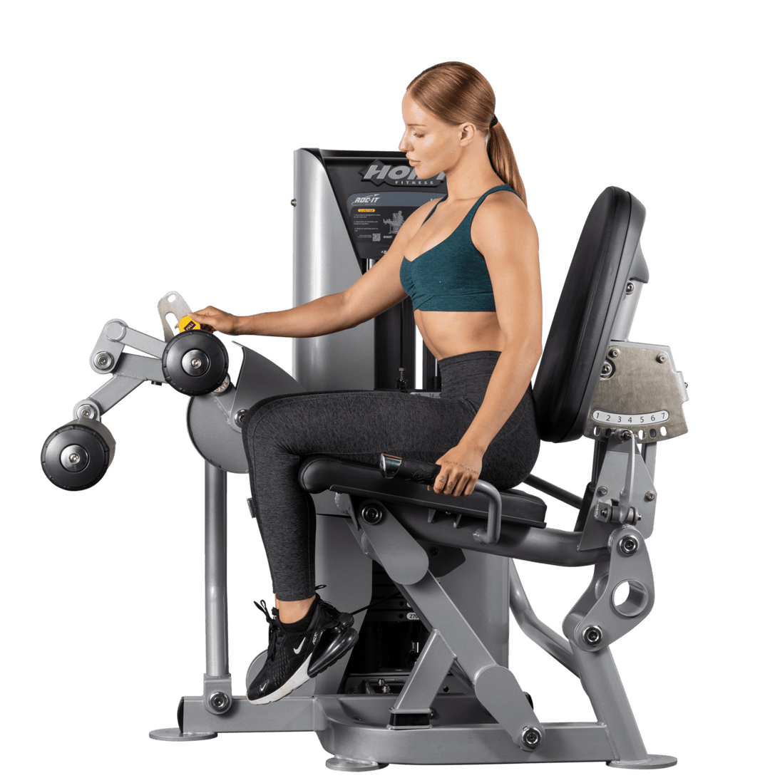 woman performing seated leg press exercise on Hoist commercial strength machine in gym setting