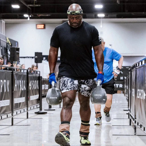 Athlete carrying Centr x HYROX Competition Octo Kettlebells during functional training.