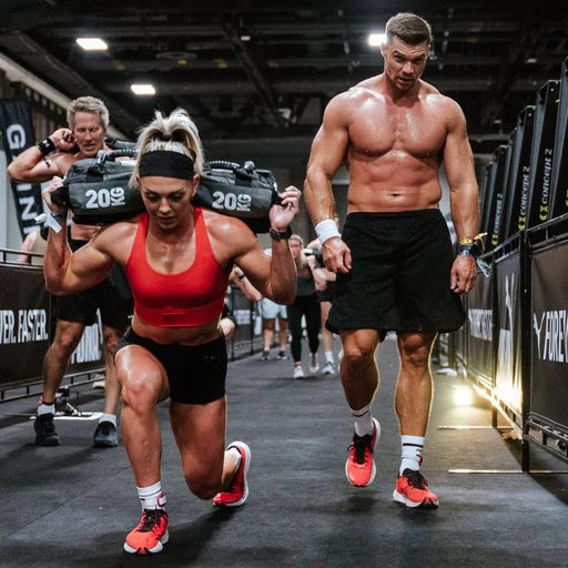 Athlete carrying the Centr x HYROX competition sandbag during functional training.