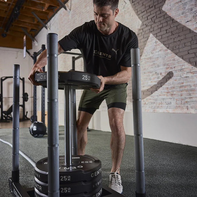 Athlete using Centr x HYROX Edge Bumper Plates during sled push training.