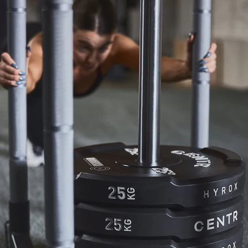 Centr x HYROX Edge Bumper Plates loaded onto a training sled for push workouts.