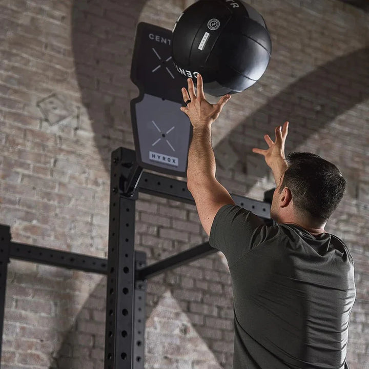 Athlete throwing the Centr x HYROX Official Wall Ball toward a wall target.