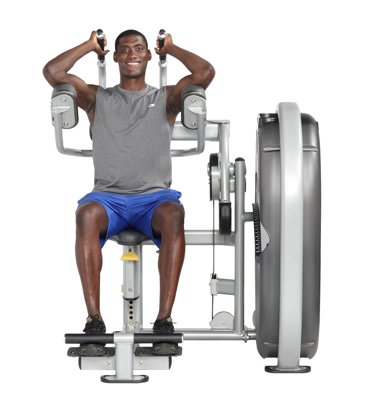 User seated on abdominal machine holding handles with torso upright preparing to perform crunch
