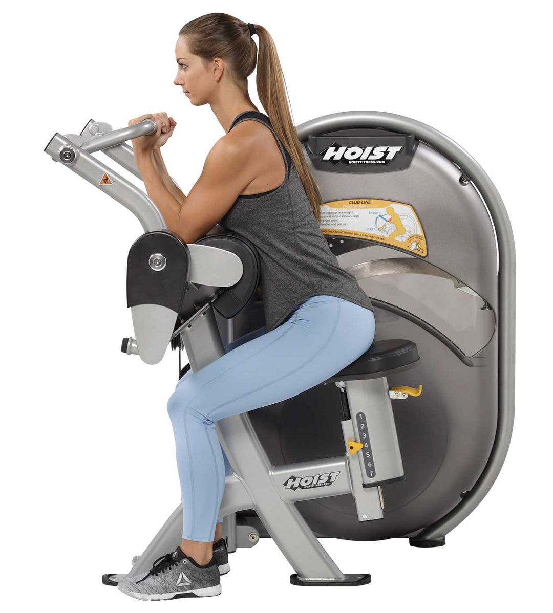 User performing seated biceps curl on machine demonstrating proper arm positioning and movement path