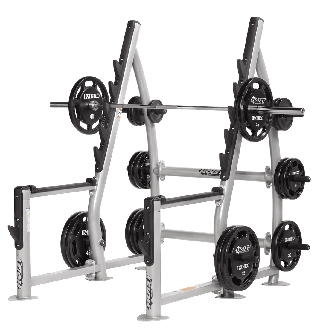 Squat rack setup with loaded barbell and weight plates stored on side pegs