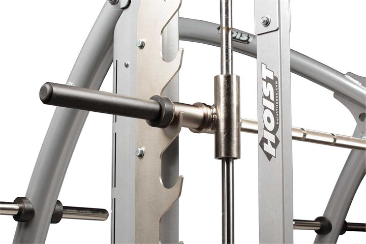 Close-up of Smith machine barbell sleeve and guide rod system showing smooth linear movement