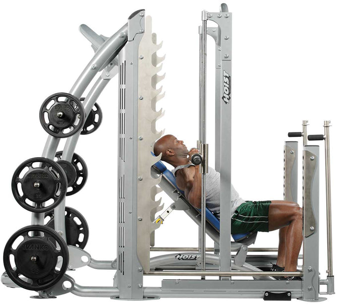 User performing incline press on dual action Smith machine with guided barbell and plate-loaded resistance