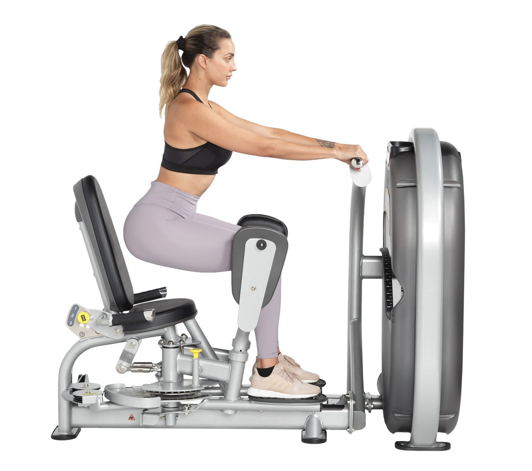 User seated performing inner thigh adduction exercise bringing legs together against resistance