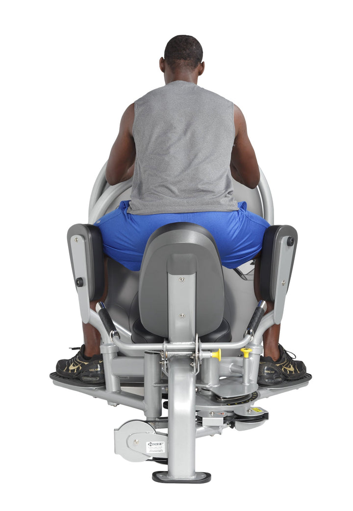 User seated performing outer thigh abduction exercise with legs pushing outward against padded supports