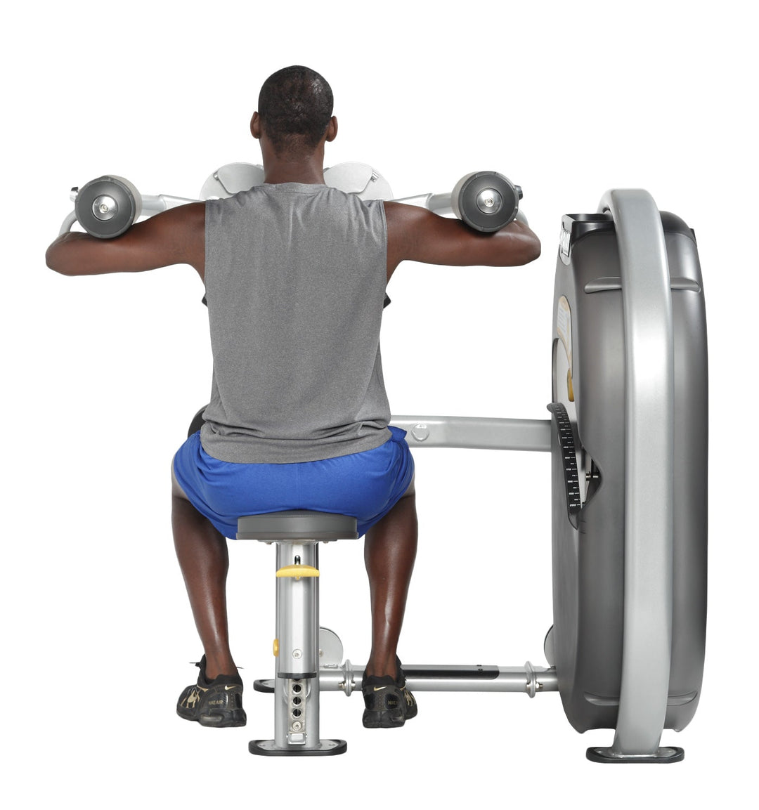 Back angle view of user seated on lateral raise machine demonstrating controlled shoulder raise movement