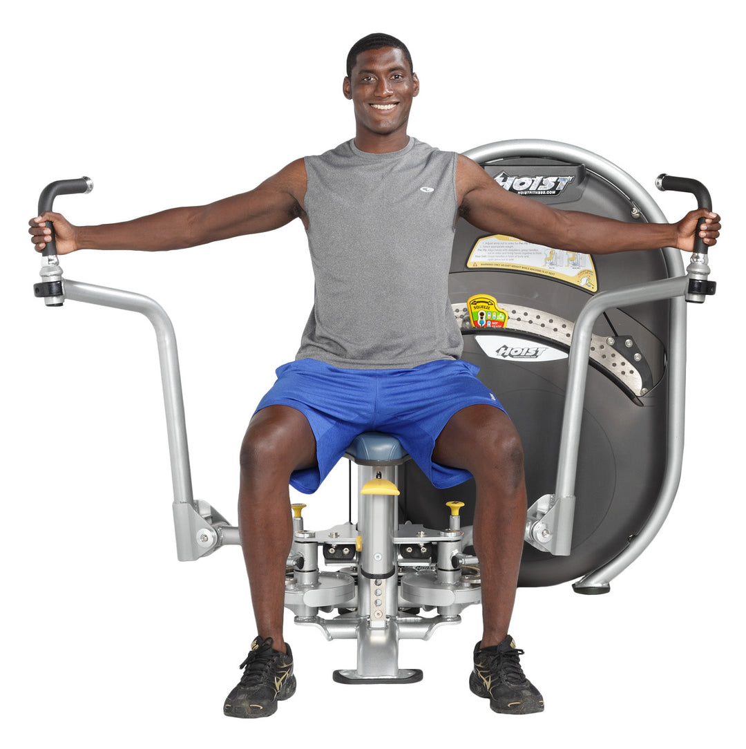 User performing chest fly movement with arms extended outward on pec fly machine