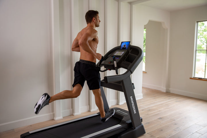 Runner using the Horizon Elite 7.0 AT treadmill during a home workout.