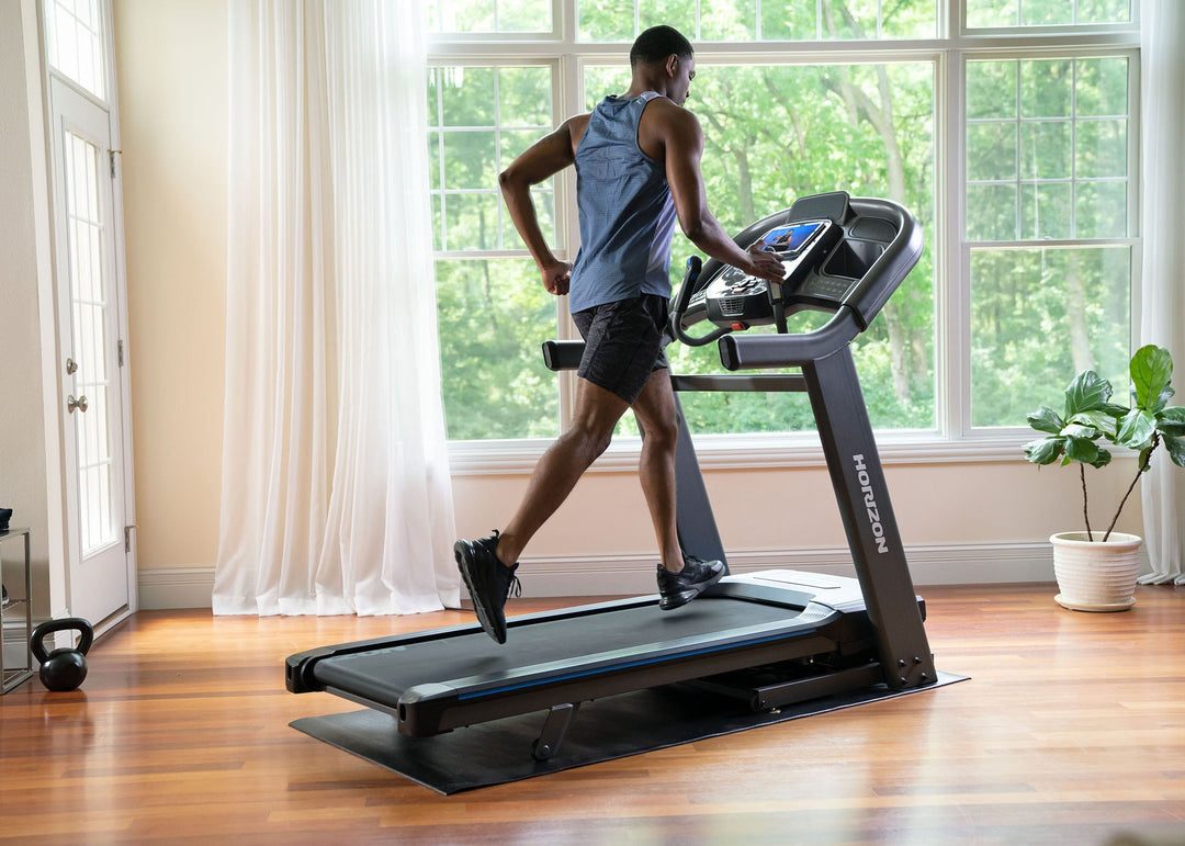Person walking on the Horizon 7.4 AT treadmill during a home workout.