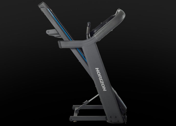 Horizon 7.4 AT treadmill folded upright for compact storage.