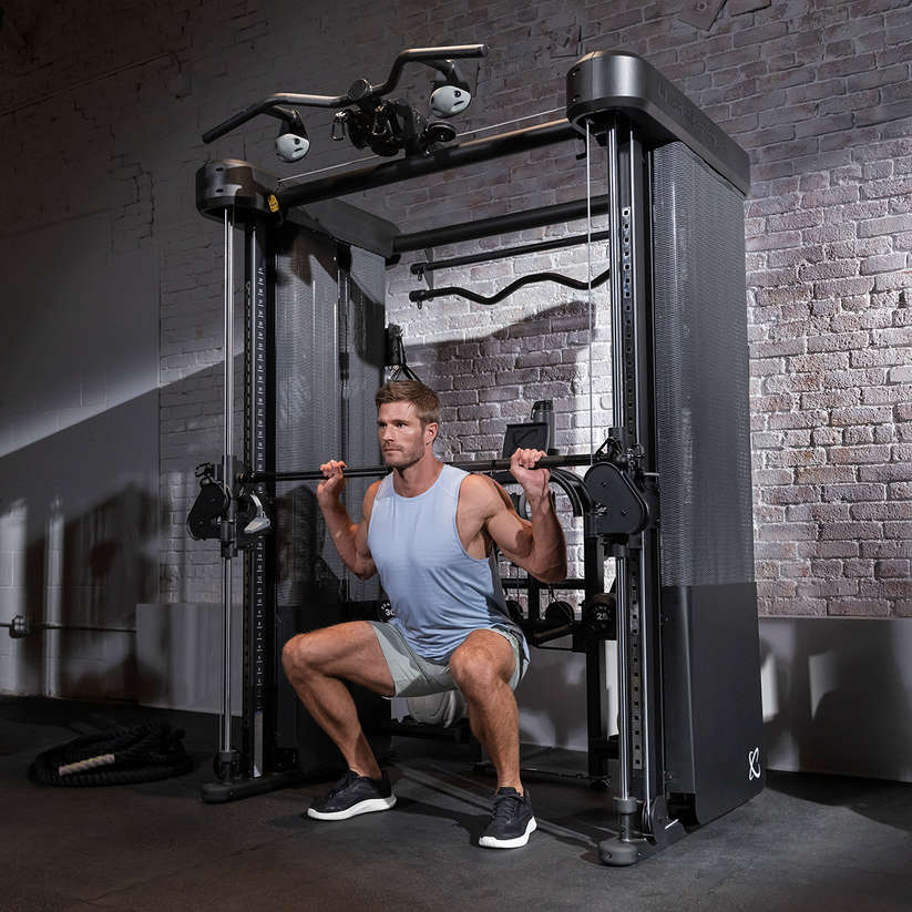 User performing strength training on Inspire FT2 Pro Smith functional trainer with Smith bar and cable system in home gym setting