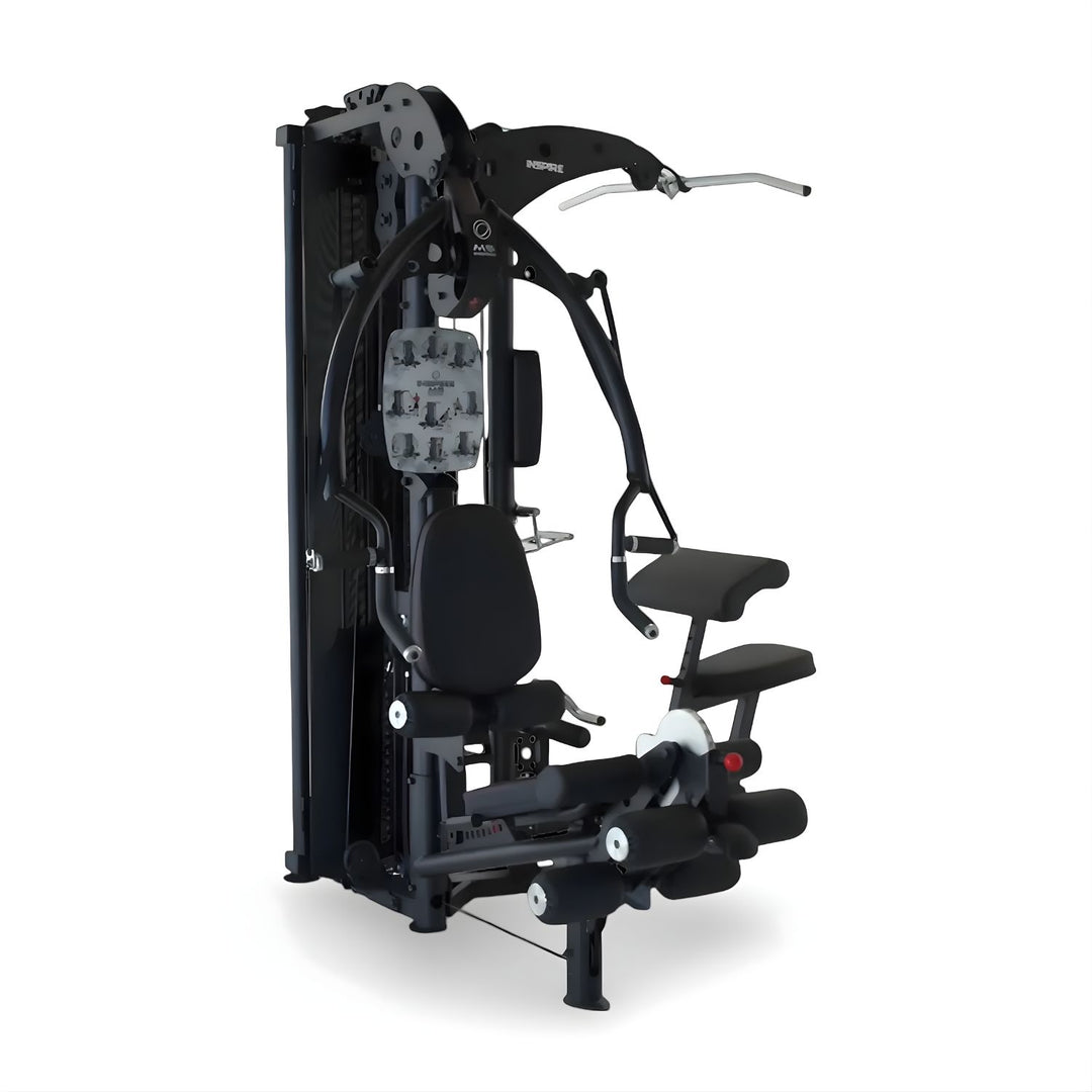 Inspire M5 multi gym front angle view showing press arms, adjustable seat, leg developer, and dual weight stacks for full body strength training