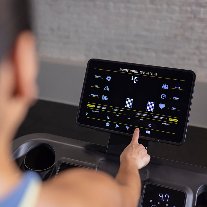 User running on Inspire T5 treadmill in home setting showing smooth running deck and ergonomic design for cardio workouts