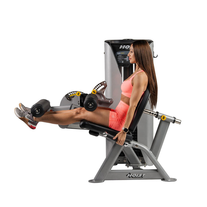 person using leg curl machine performing hamstring exercise in seated position