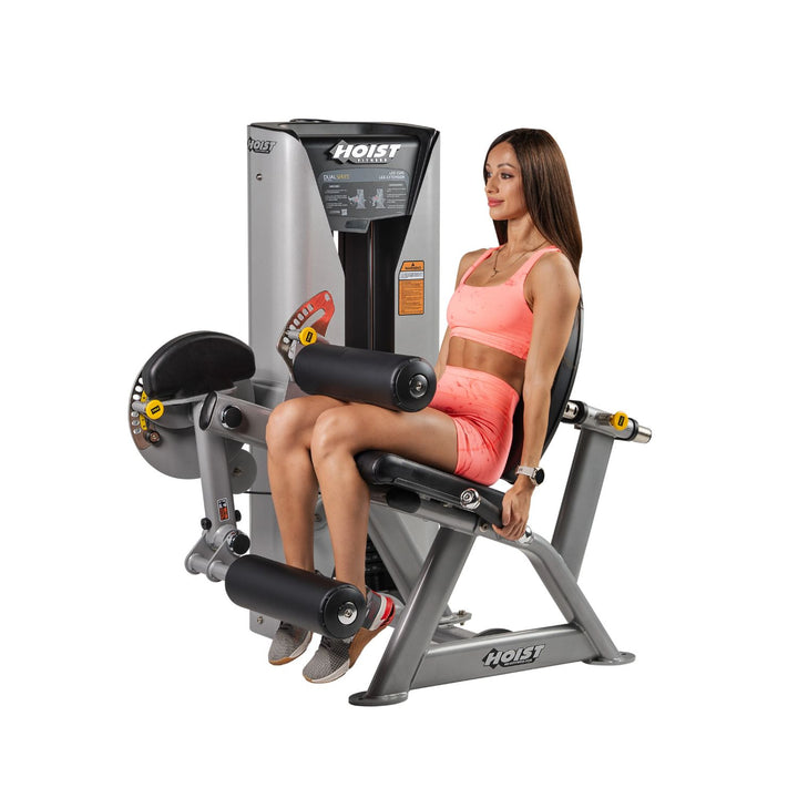 person using leg extension machine performing quadriceps exercise in gym