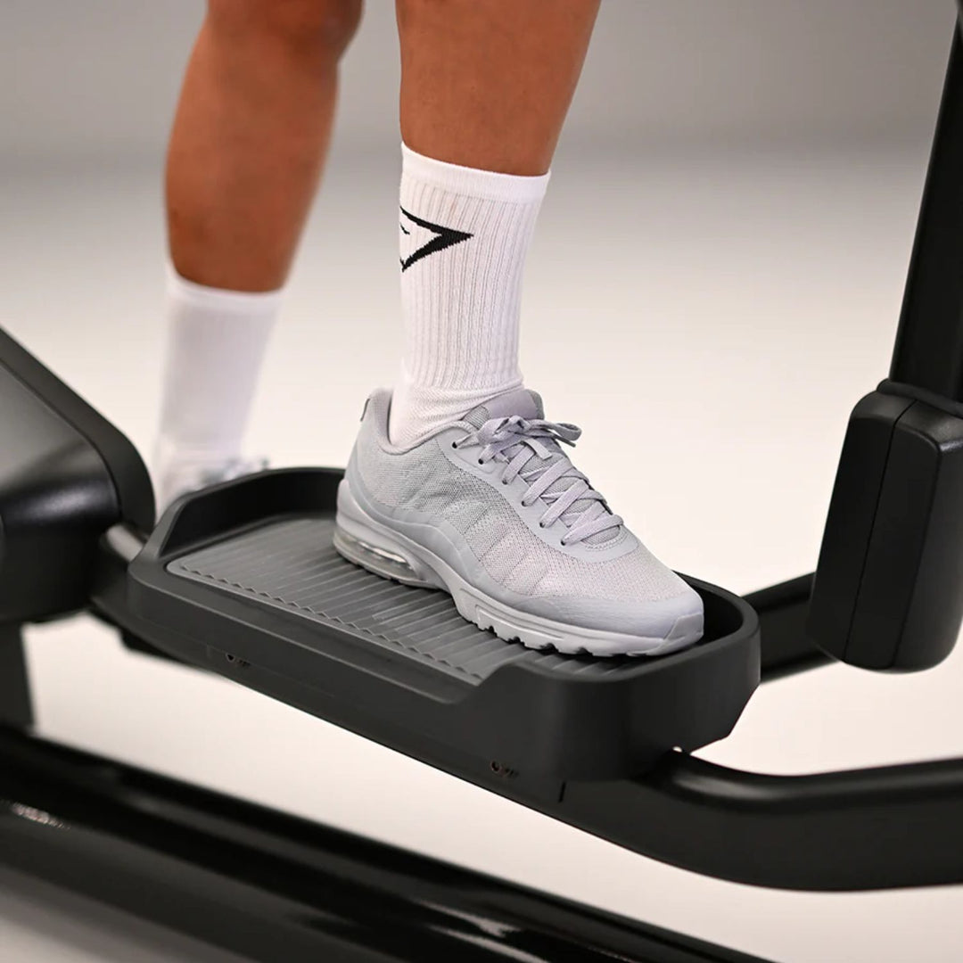 Close-up of a user’s foot on the Life Fitness Club Series Plus elliptical pedal showing textured foot platform and smooth stride motion