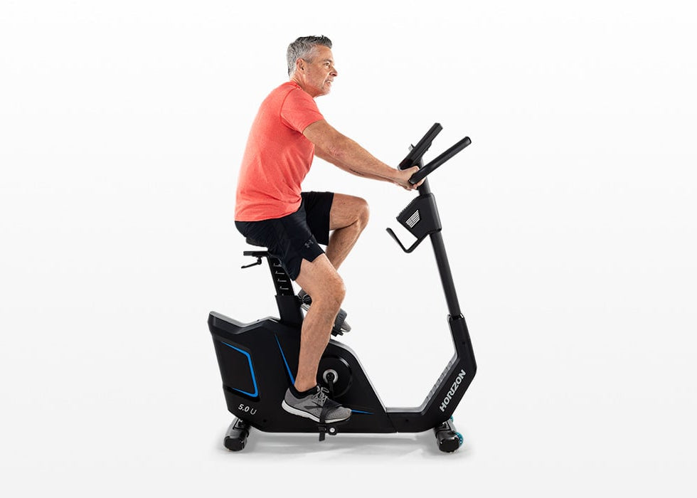 Male user exercising on the Horizon 5.0U upright exercise bike.