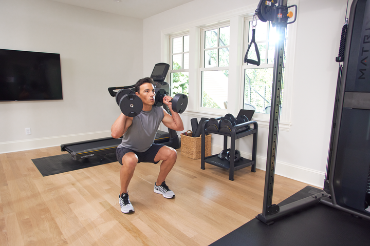 Matrix dumbbells used on floor during workout showing free weight exercises for full body strength training at home