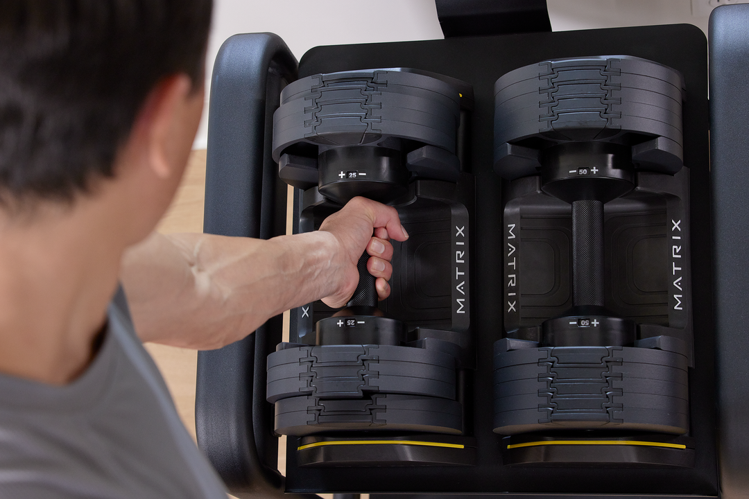 Matrix dumbbells set arranged on rack showing multiple weight options for full body strength training workouts