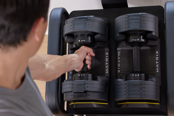 Matrix dumbbells set arranged on rack showing multiple weight options for full body strength training workouts