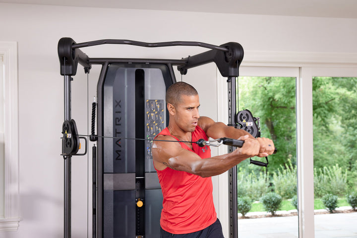 Male performing baseball swing exercise on Matrix functional trainer with cable resistance in front view for strength training